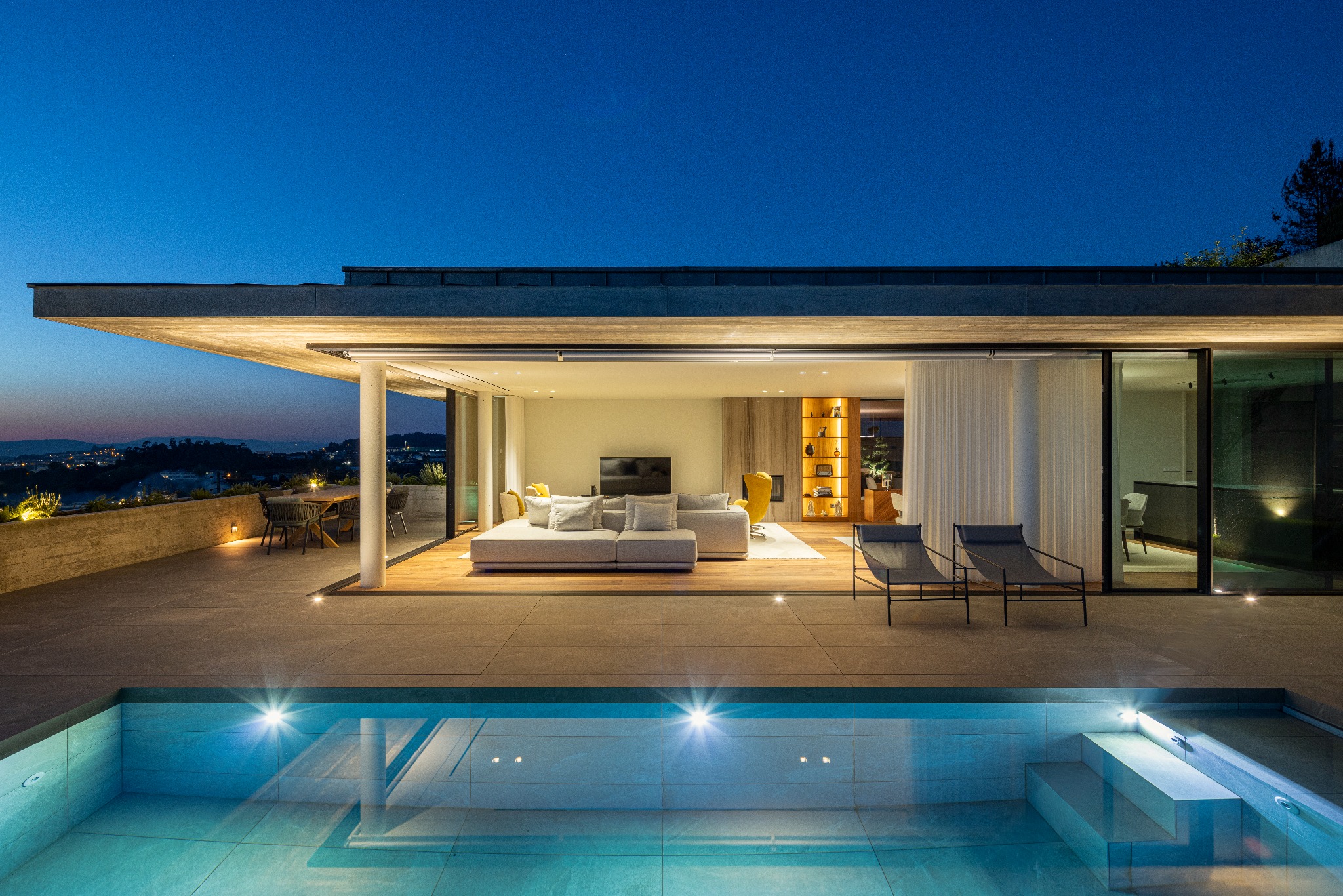 Casa A aberta para a piscina e a paisagem ao anoitecer
