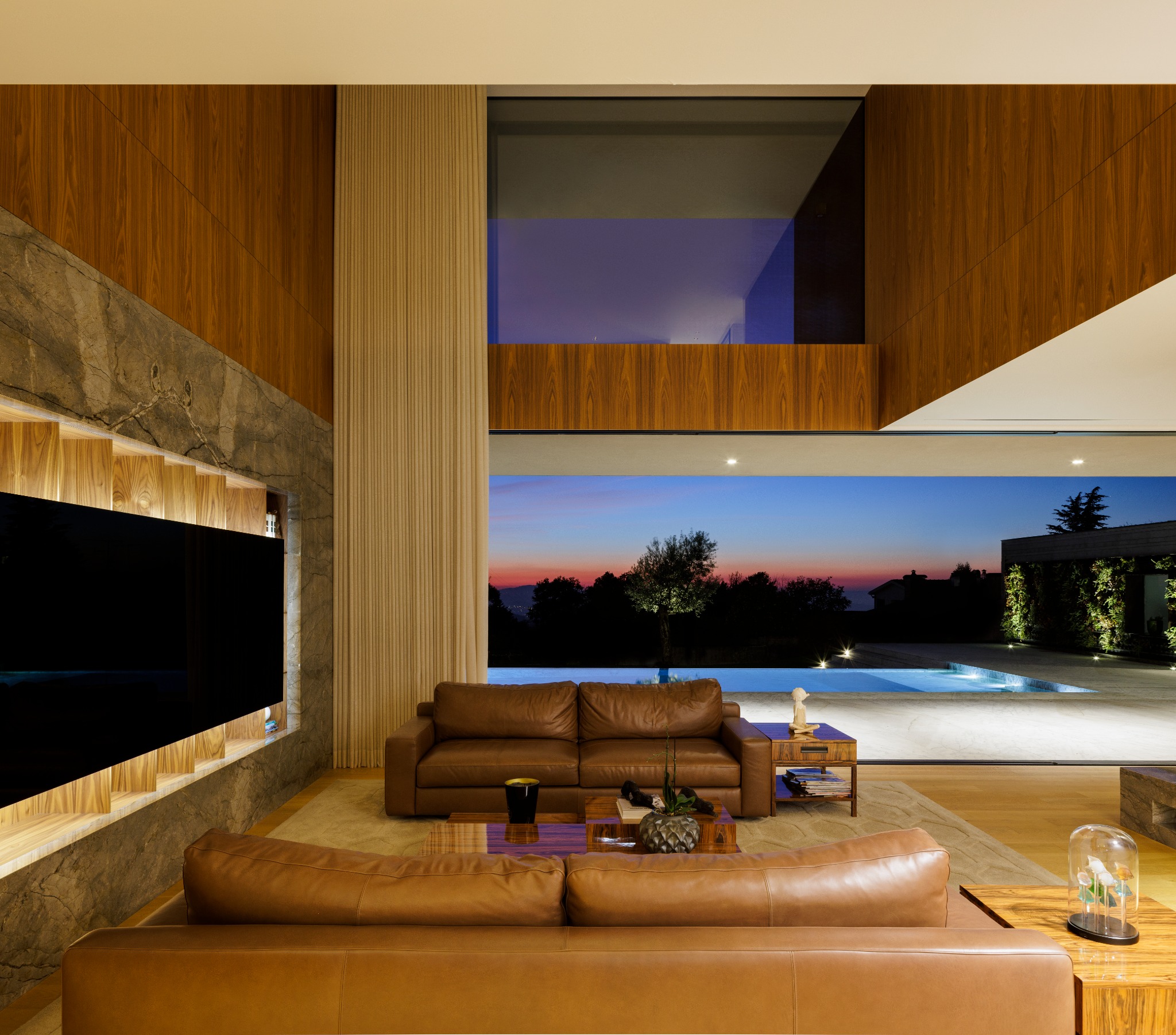 Casa D, sala aberta para a paisagem ao anoitecer